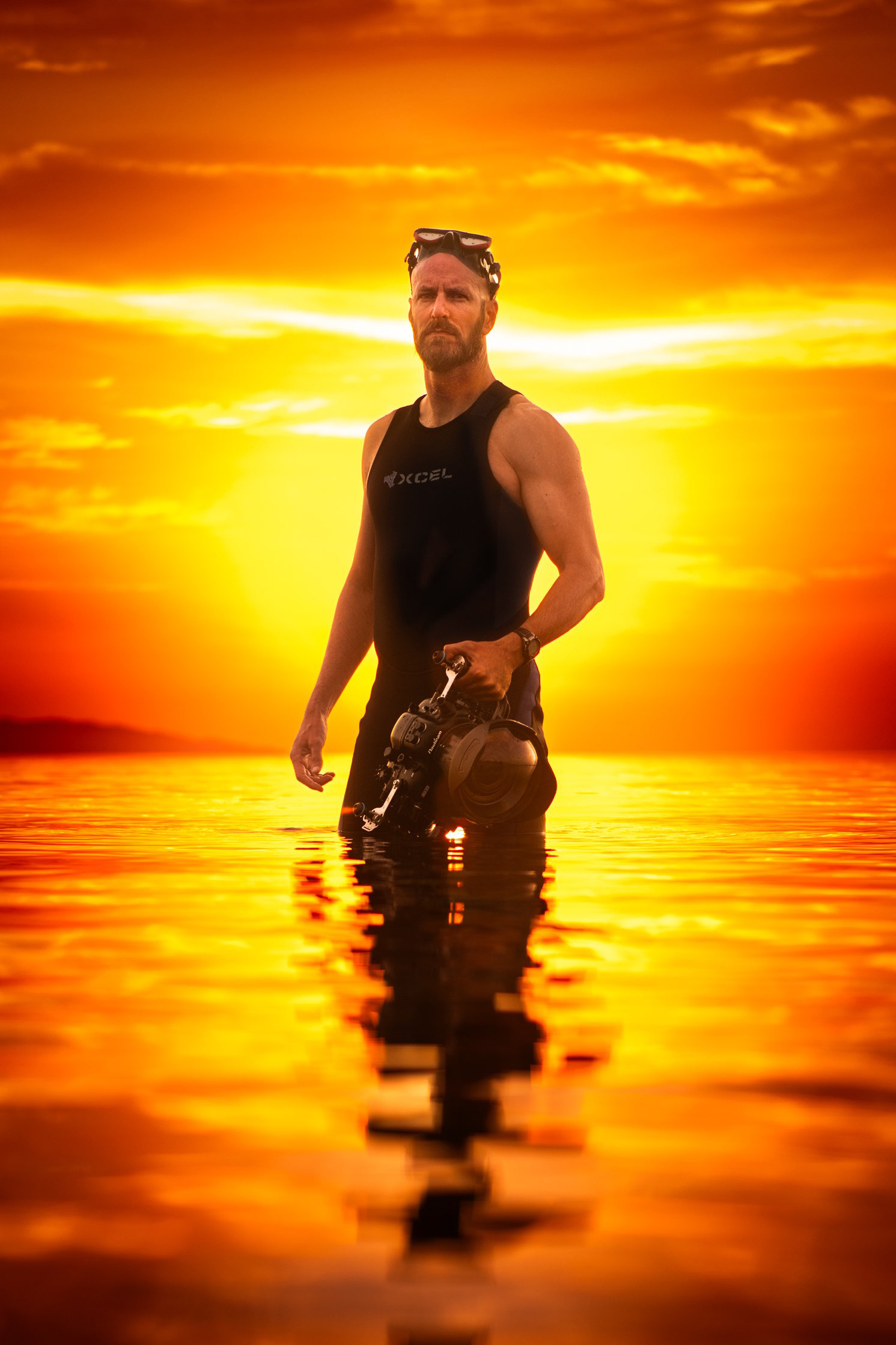 photo of George T Probst in the Sea of Cortez with a fiery sunrise in the background